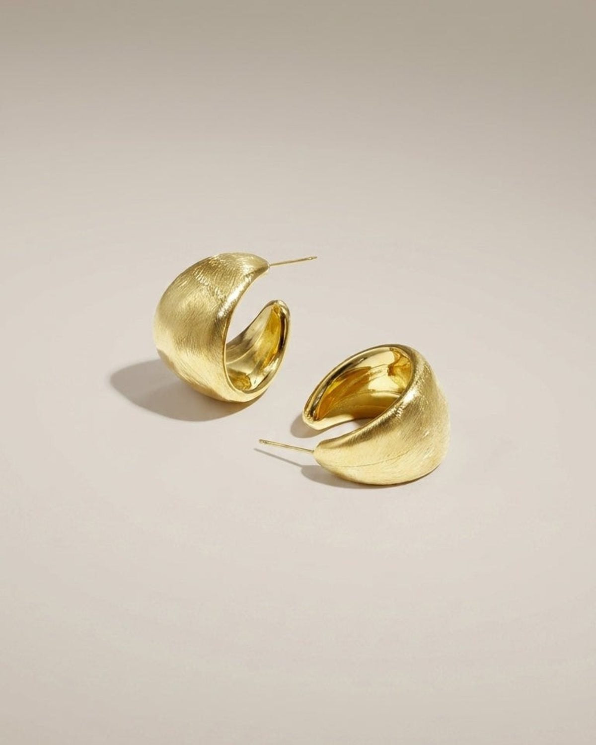 Chunky brushed gold hoop earrings with a thick, textured finish and post back closure.