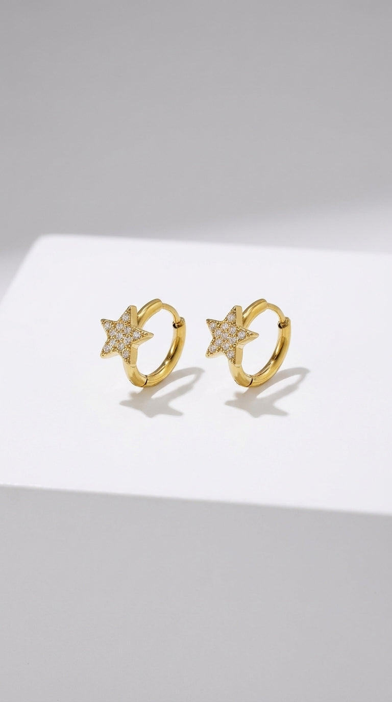 Gold-finished hoop earrings featuring pavé-set crystal star charms.