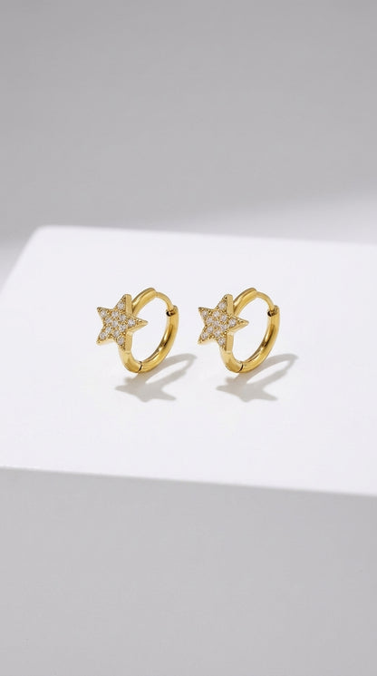 Gold-finished hoop earrings featuring pavé-set crystal star charms.
