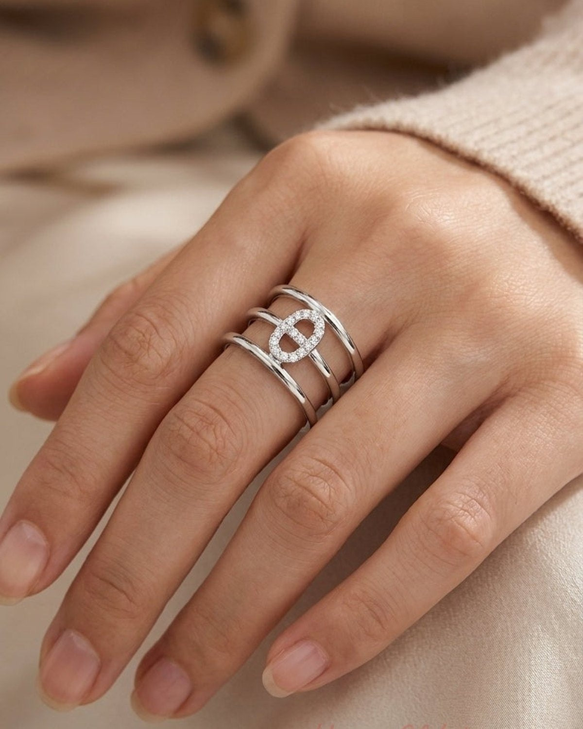 Silver multi-band ring with three parallel tiers and a central pavé-set elliptical motif.