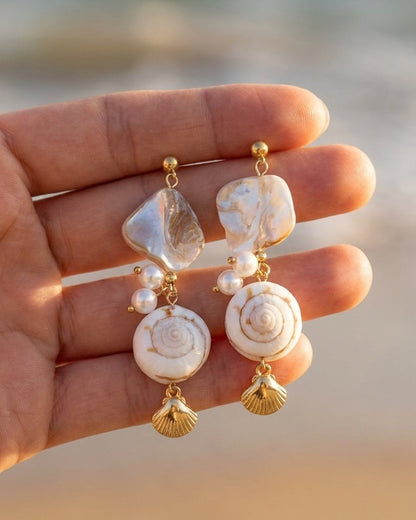 Gold drop earrings featuring white mother-of-pearl, round shells, and dangling shell charms.