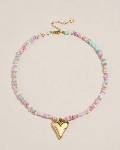 A necklace of multicolored pastel chip beads featuring a polished gold heart pendant.