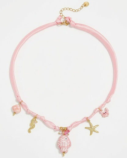 Pink braided cord necklace with gold and pink ocean-themed charms including a fish, seahorse, and starfish.