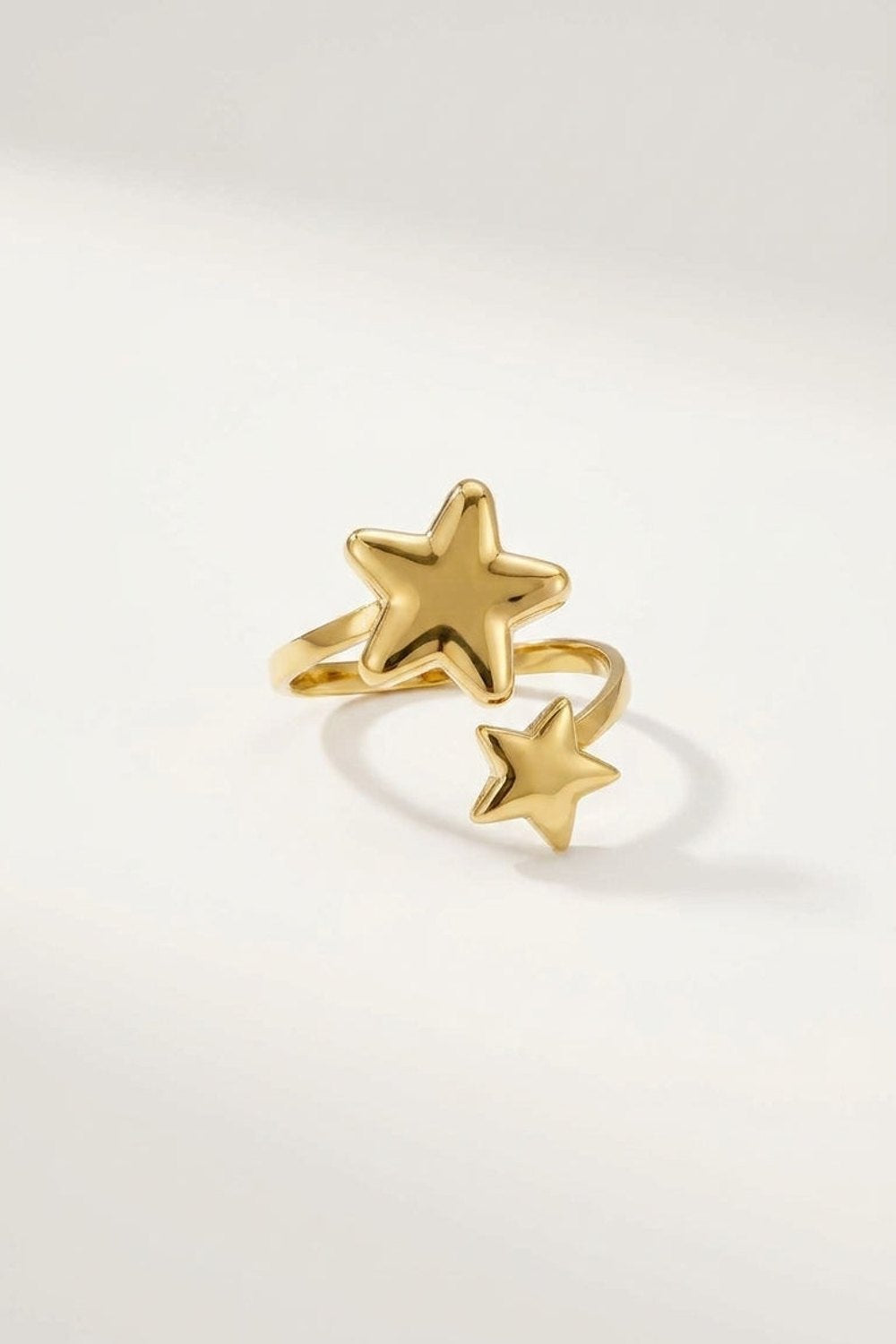 Gold minimalist star ring with an open band featuring one large star and one smaller star.