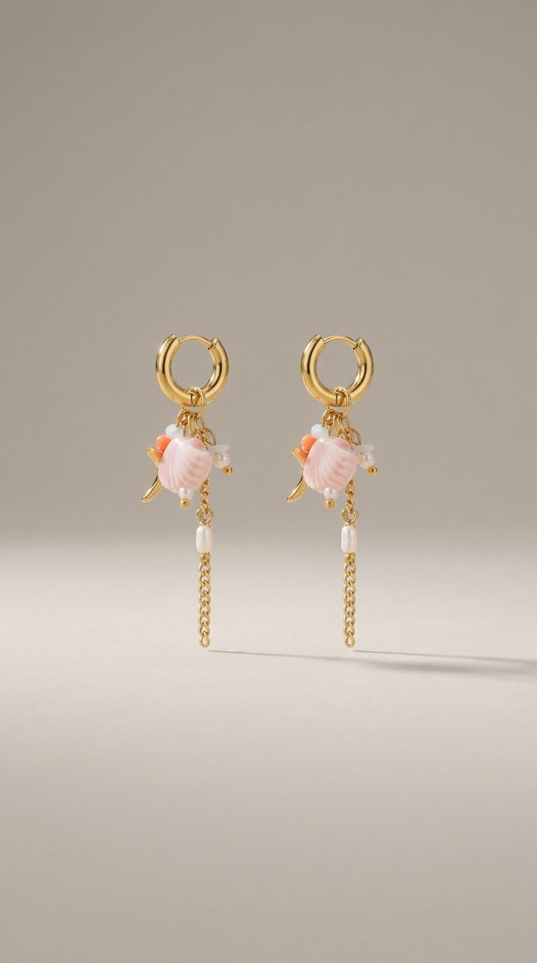 Oceanic Gold Drop Earrings featuring gold hoops with dangling pink shell charms, small pearls, and gold chains.