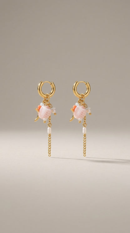 Oceanic Gold Drop Earrings featuring gold hoops with dangling pink shell charms, small pearls, and gold chains.