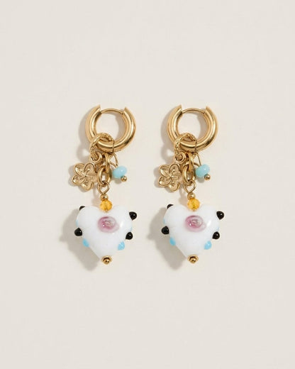 Gold hoop drop earrings with white heart charms featuring pink centers and colorful bead accents.