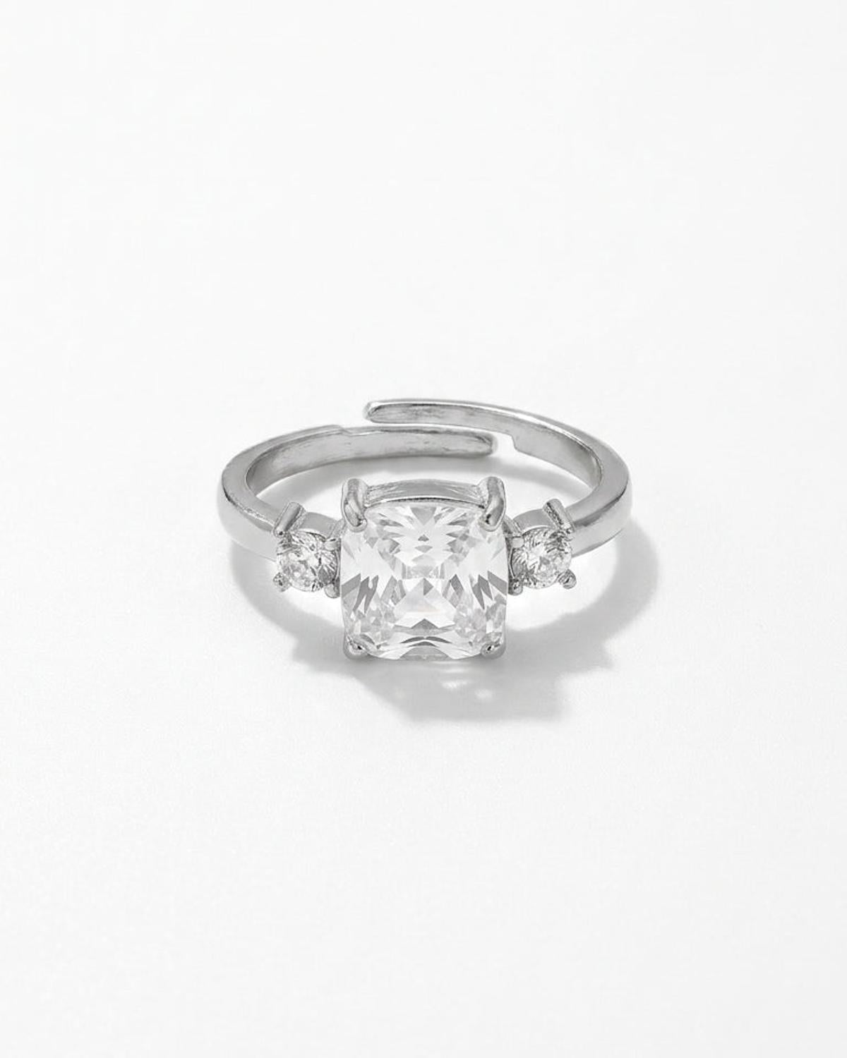Silver ring with a large cushion-cut center rhinestone flanked by two small round rhinestones.