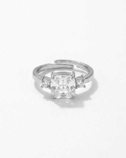 Silver ring with a large cushion-cut center rhinestone flanked by two small round rhinestones.