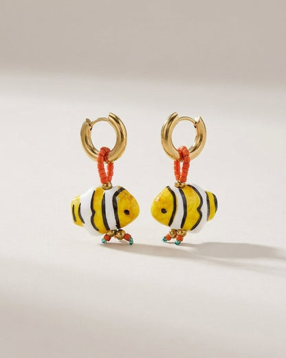 Glass fish bead earrings with gold hoops, orange seed beads, and yellow, white, and black striped fish pendants.