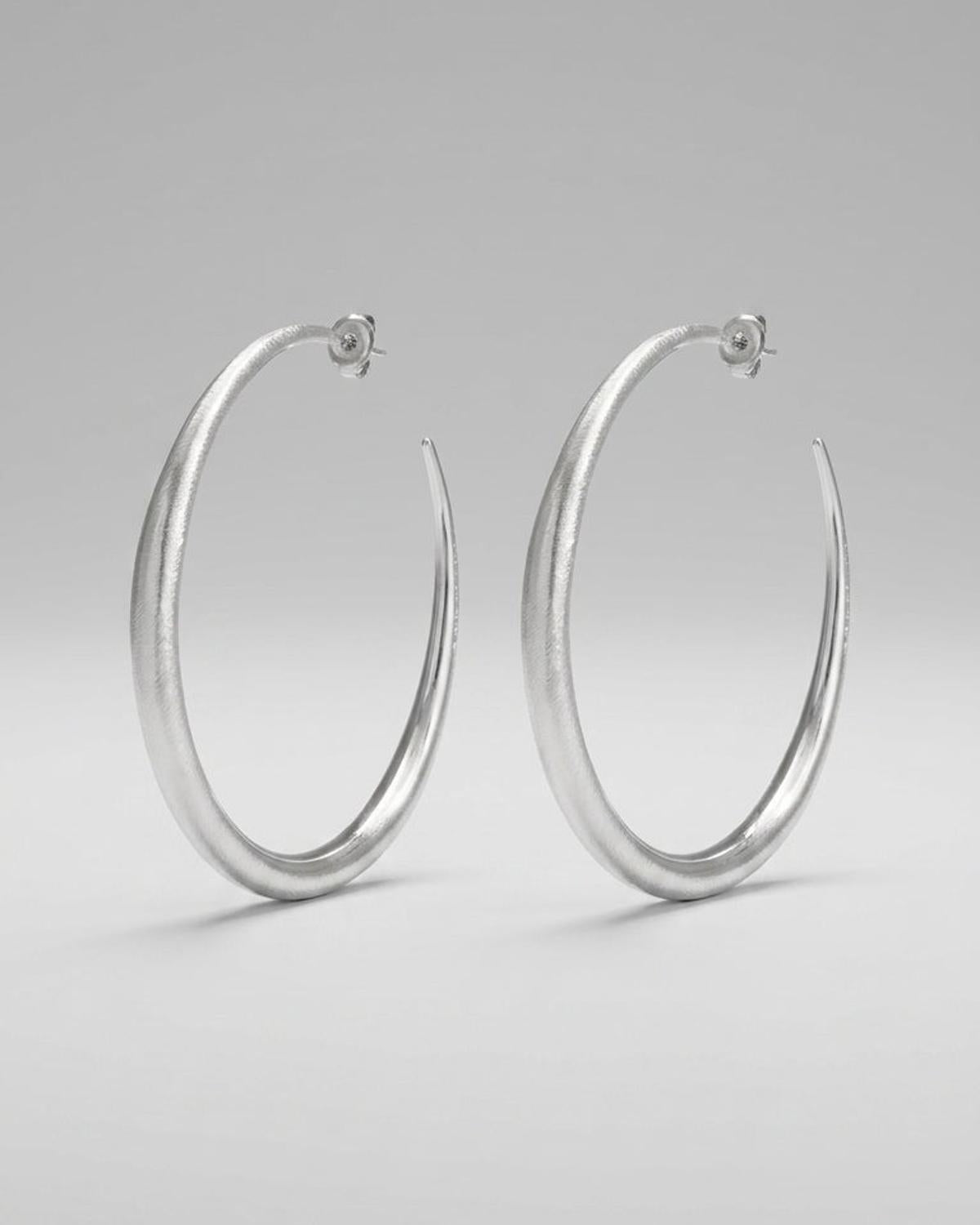 Large, textured silver hoop earrings with a tapered, melted design.