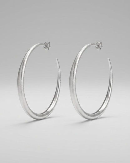 Large, textured silver hoop earrings with a tapered, melted design.