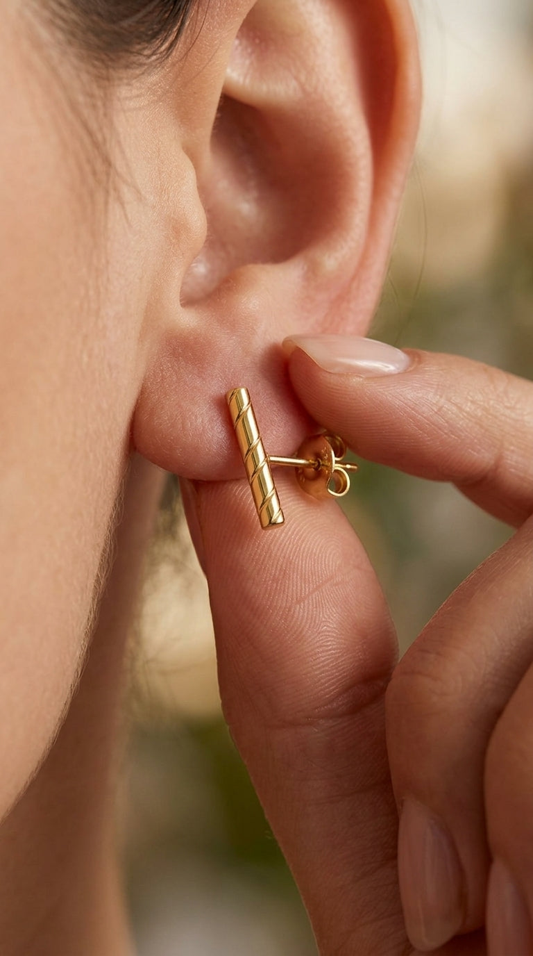 Gold-plated stud earring featuring a thin, vertical bar with an elegant twisted, rope-like texture.