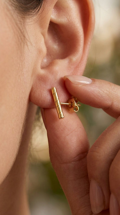 Gold-plated stud earring featuring a thin, vertical bar with an elegant twisted, rope-like texture.