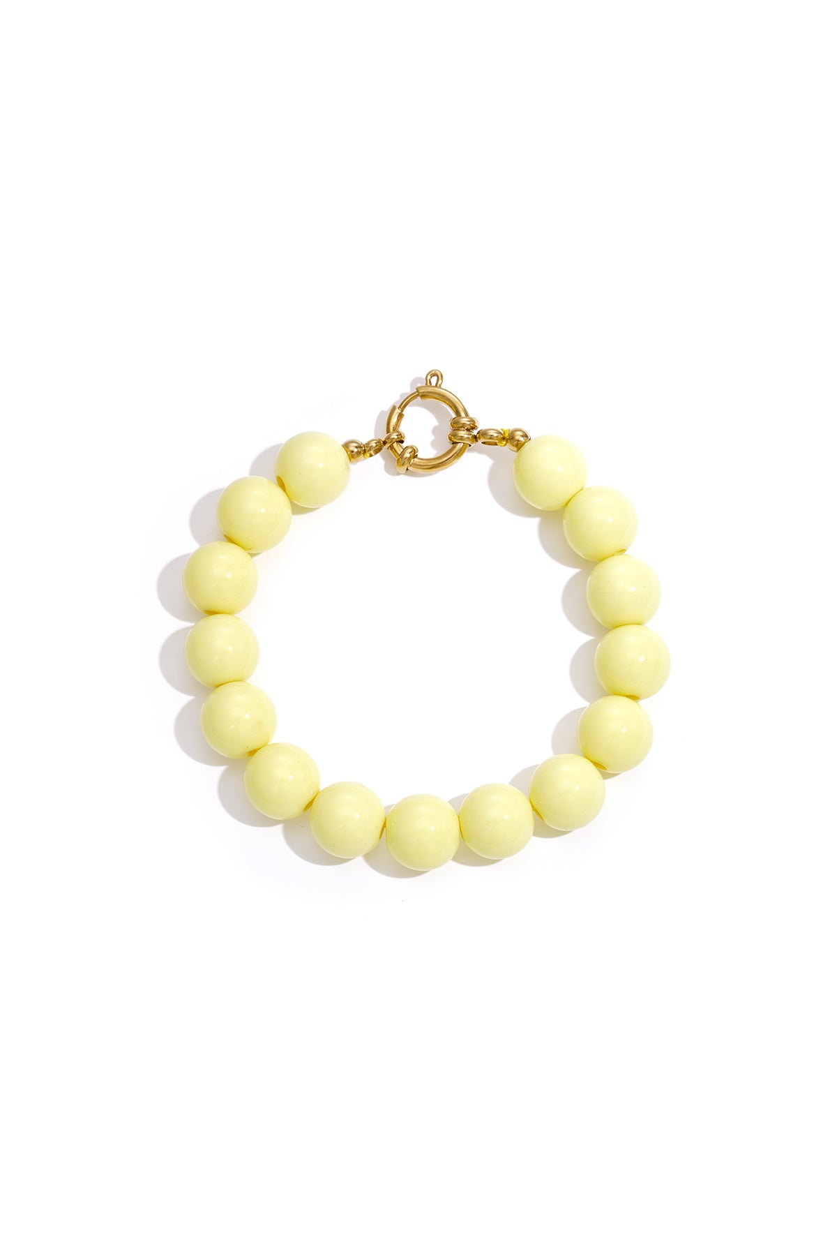 Bracelet of round, pale yellow resin beads with a gold-toned circular clasp on a plain white background.