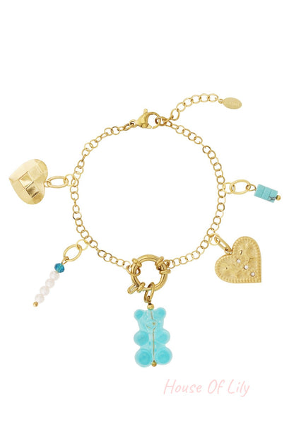 Close-up of gold charm bracelet displaying detailed charms arranged around chain with lobster clasp on white background