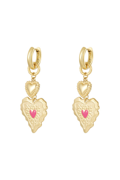 Pair of gold heart drop earrings with textured double hearts and pink center detail on white background