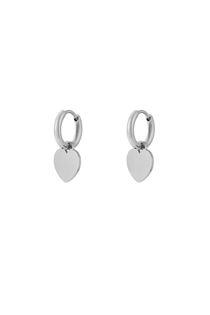 Silver hoop earrings with smooth heart-shaped drop charms on white background