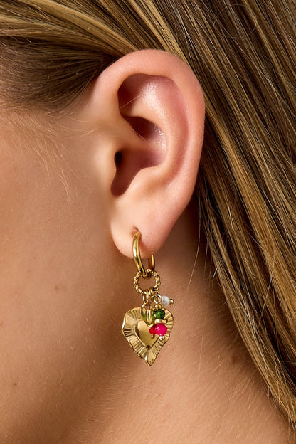 Detailed side view of model wearing gold-tone hoop earring featuring textured heart charm with colorful beads and pearl
