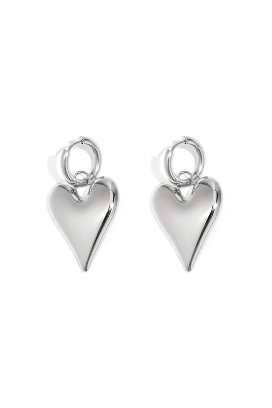 Pair of shiny silver chubby heart-shaped hoop earrings on white background