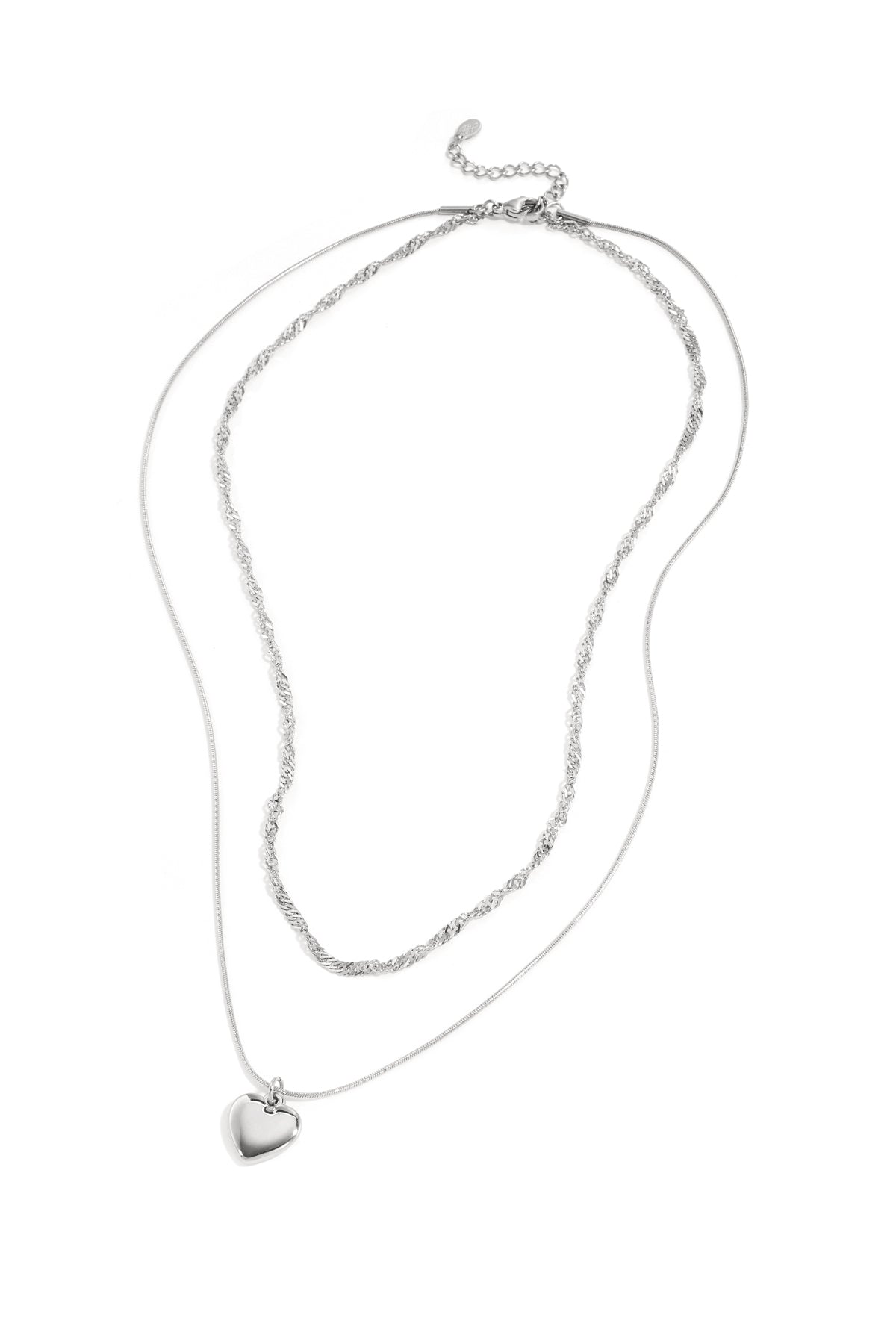 Silver two-layer necklace with twisted chain and heart-shaped pendant laid on white background