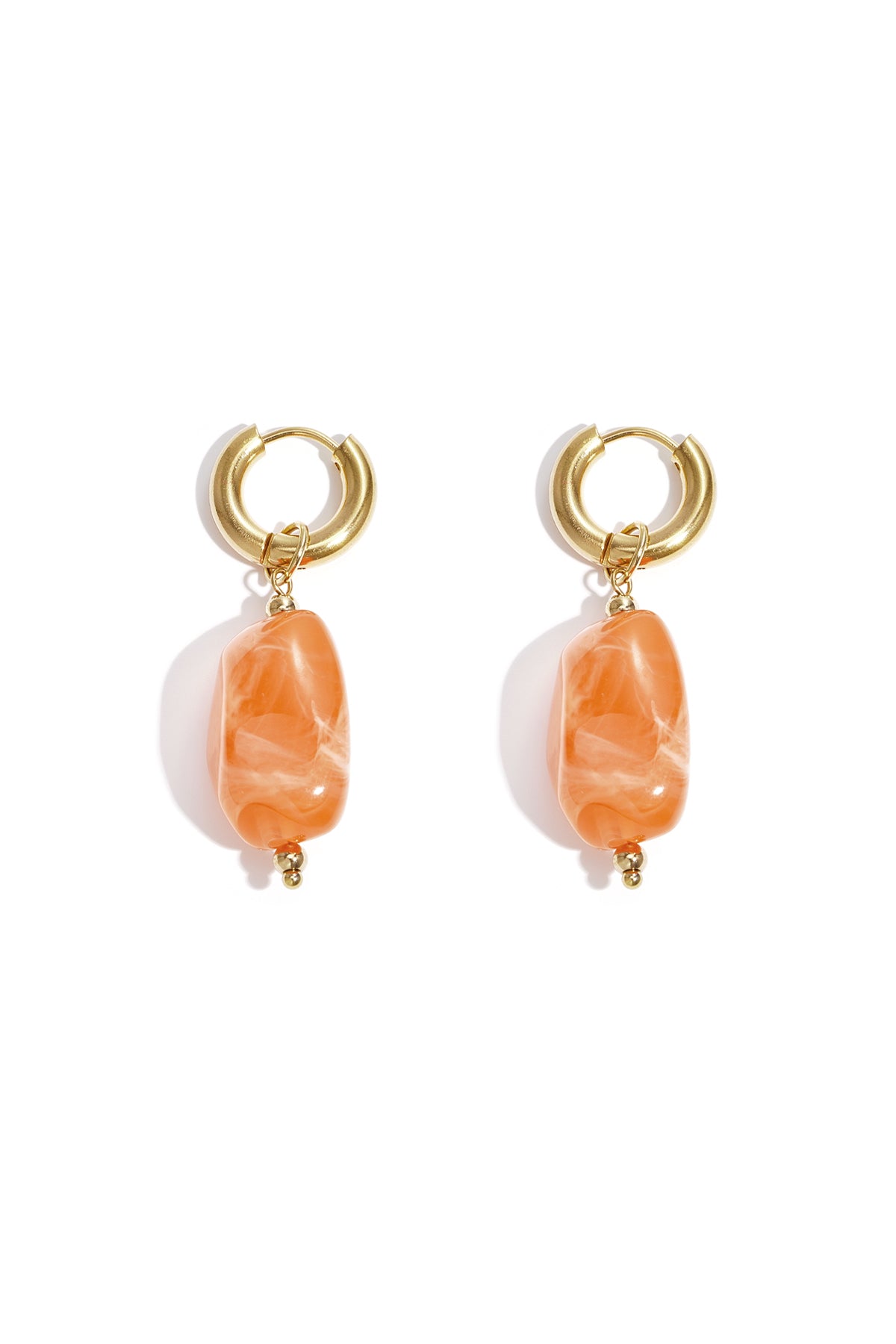 Gold hoop earrings with irregular berry red resin drop beads on white background
