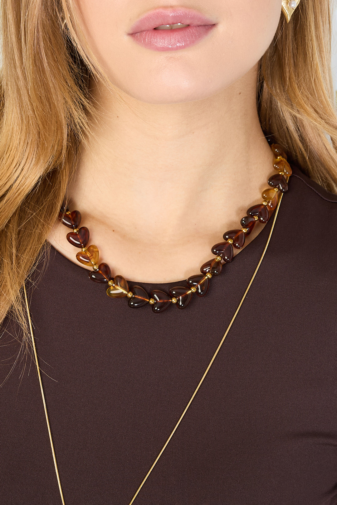 Brown and amber gradient heart bead necklace with gold spacers on white background