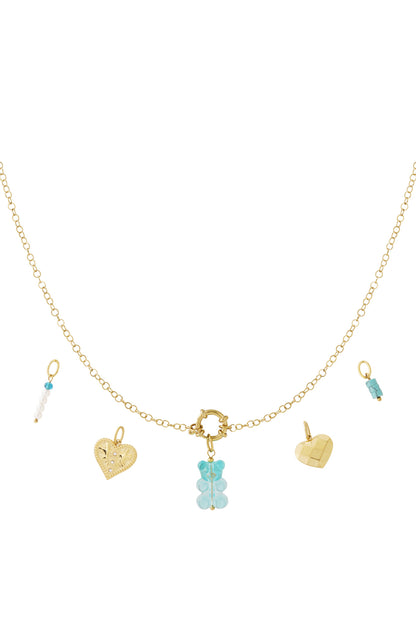 Gold-plated chain necklace with interchangeable charms including a blue gummy bear, two different heart-shaped pendants, and bead charms in white and turquoise