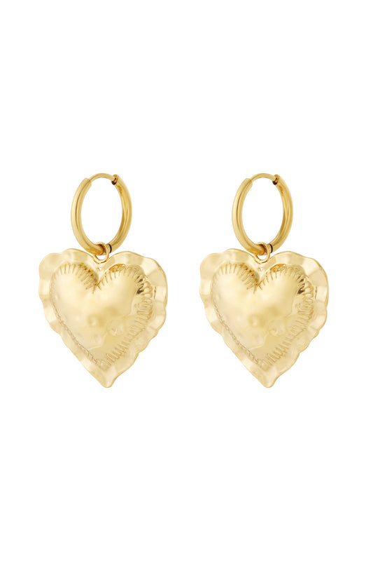 Pair of gold tone heart drop hoop earrings with hammered texture on white background