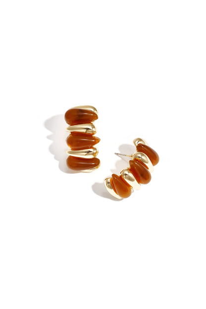 Pair of chunky resin and gold alloy hoop earrings on white background