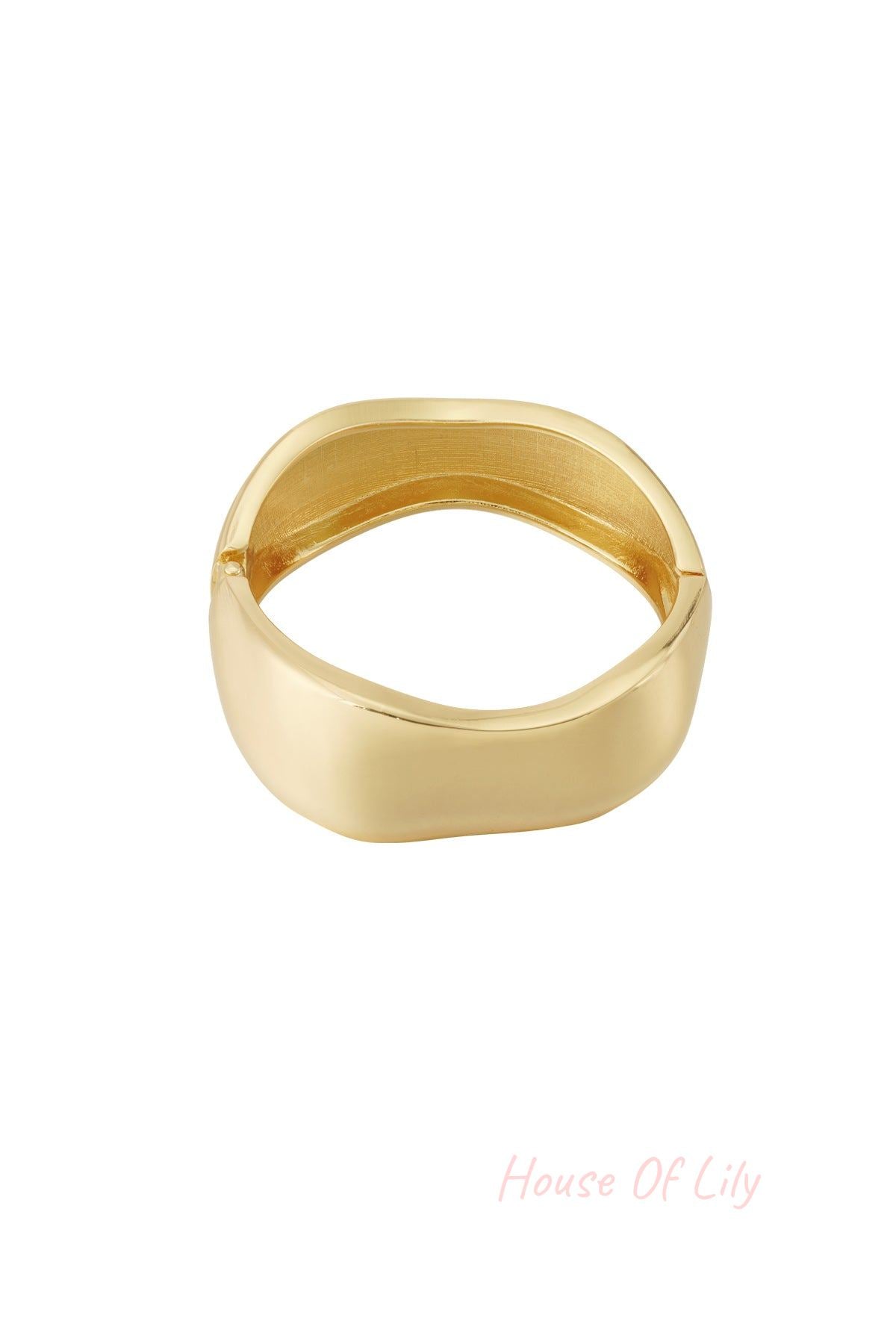 Single golden irregular-shaped sculpted bangle bracelet with polished surface on a white background