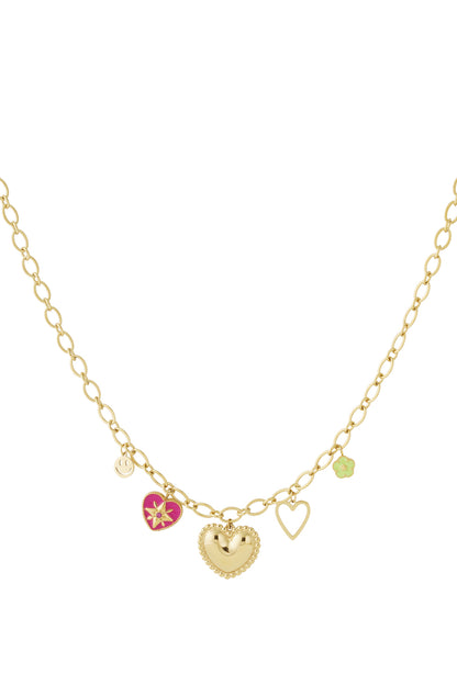 Gold-tone heart charm necklace with pink enamel heart, smiley face, green flower, and open heart charms on oval link chain