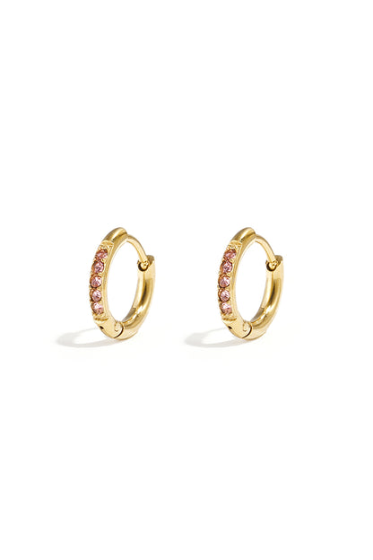 Pair of small gold hoop earrings with pink rhinestones on a white background