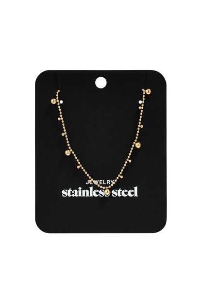 Dainty Dot Energy gold-toned stainless steel chain necklace with small hanging bead charms on a black display card.