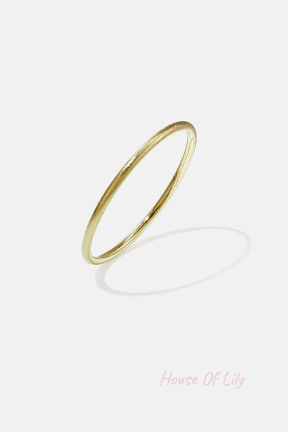 Minimalist gold circle bangle with a soft texture on white background