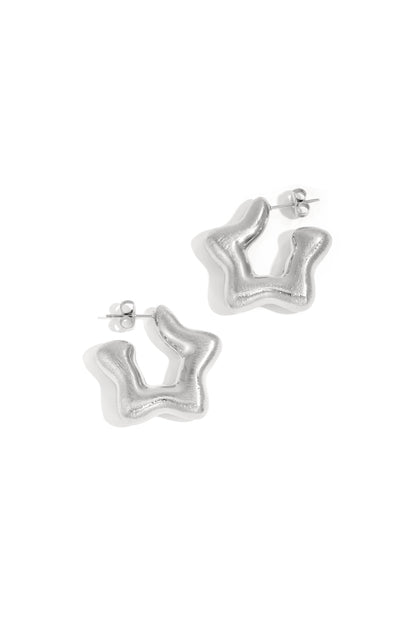 Pair of silver modern sculptural hoop earrings with a smooth, wavy abstract shape displayed on white background
