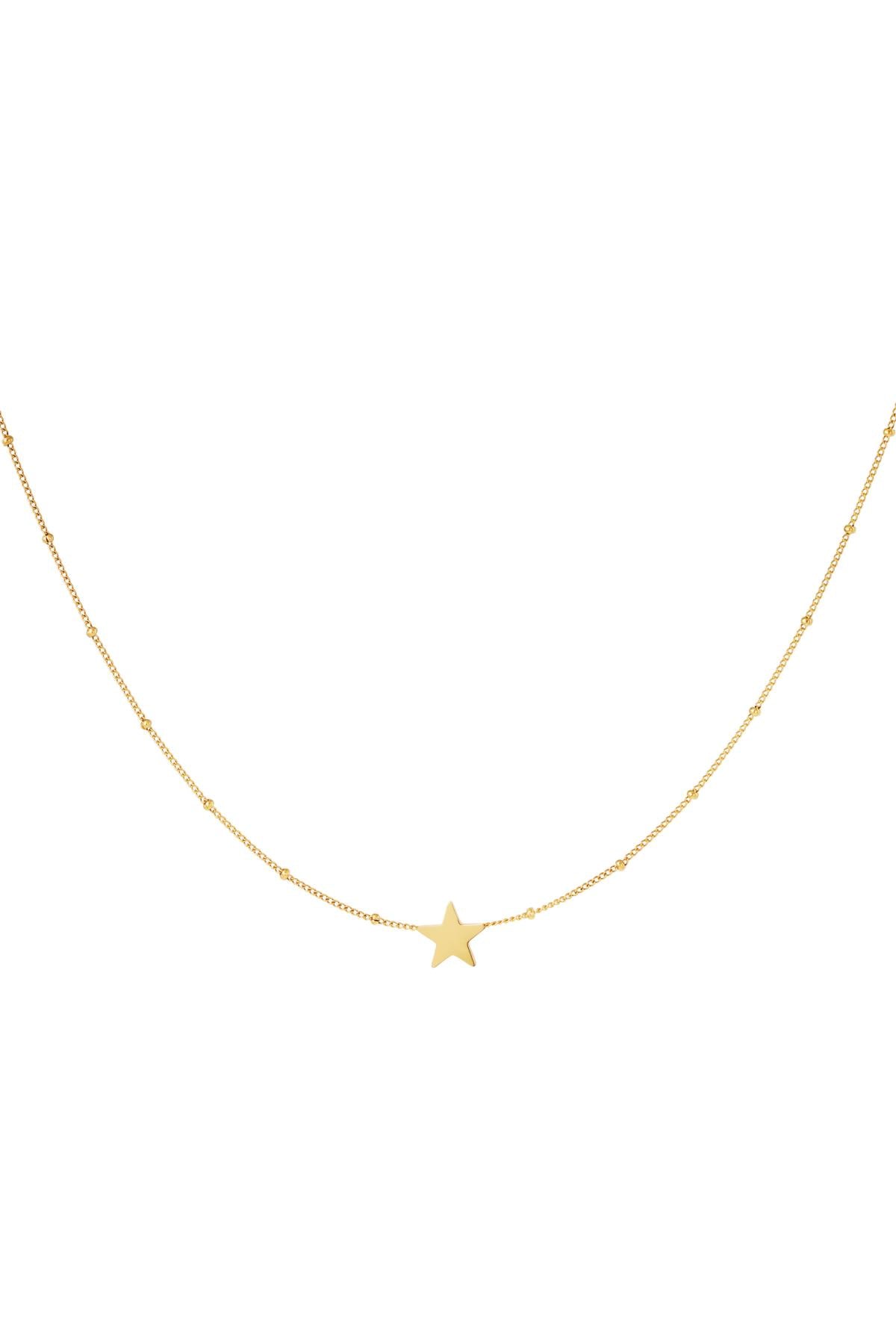 Close-up of a delicate gold star pendant on a fine chain necklace with small beads spaced evenly, displayed on a white background