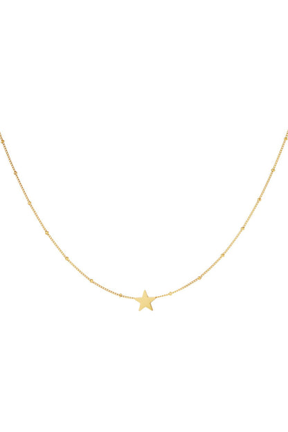 Close-up of a delicate gold star pendant on a fine chain necklace with small beads spaced evenly, displayed on a white background