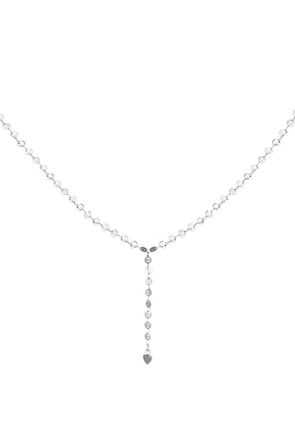 Close-up view of the silver version of the Y-chain necklace with circular discs and a small heart charm at the end