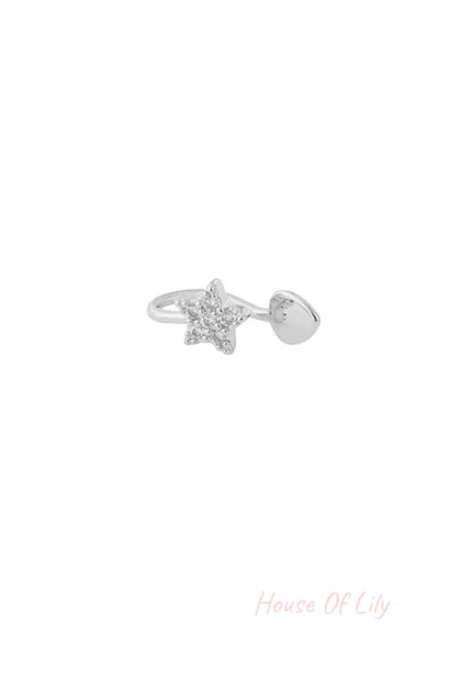 Close-up of silver star-shaped ear and nose cuff with sparkling cubic zirconia stones on a white background