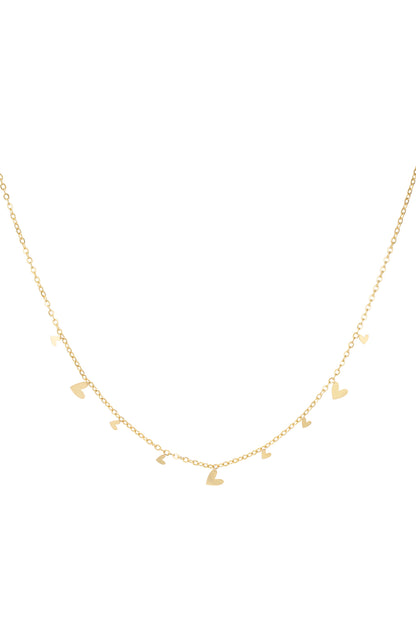 Close-up of a delicate gold necklace featuring multiple small heart charms evenly spaced along a fine chain on a white background
