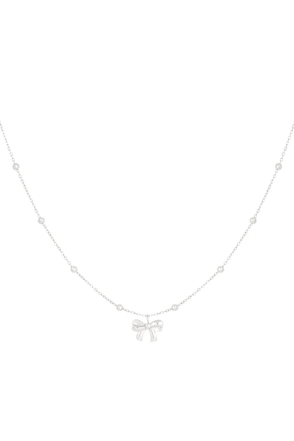 Silver delicate chain necklace with small round beads and a central bow pendant on a white background