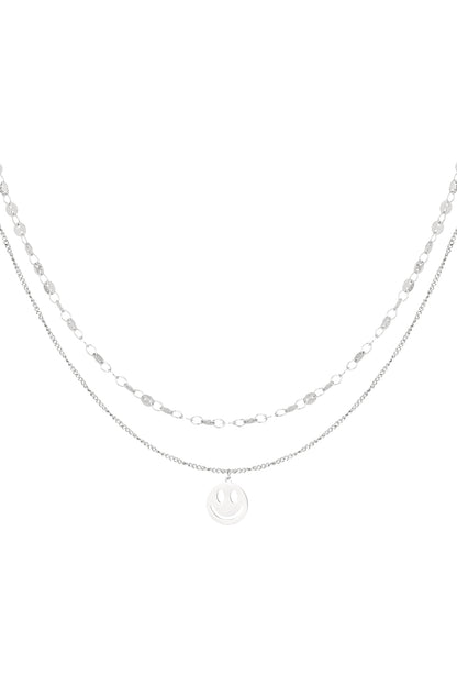 Silver layered necklace with smiley face pendant isolated on white background