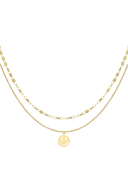 Gold layered necklace with smiley face pendant isolated on white background