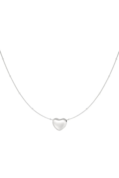 Silver heart pendant necklace with spaced beads on chain displayed on a white background