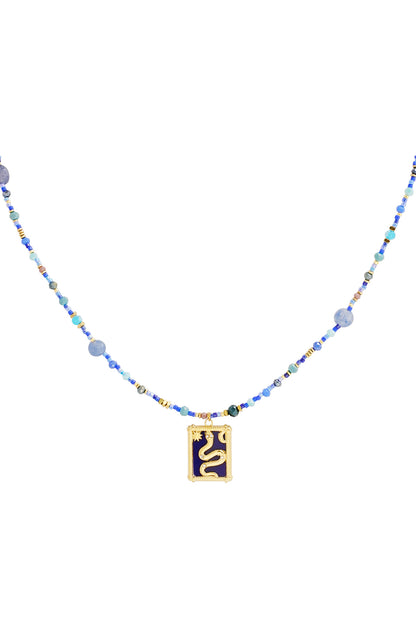Close-up of a blue beaded necklace with a gold snake pendant on a white background