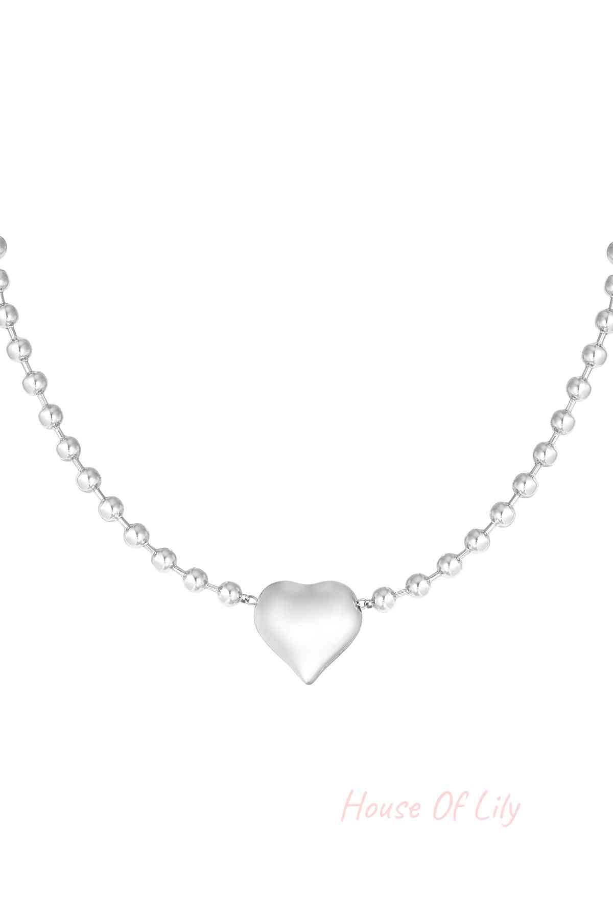Silver stainless steel beaded necklace with heart-shaped pendant against white background