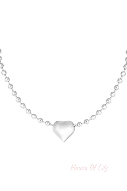 Silver stainless steel beaded necklace with heart-shaped pendant against white background