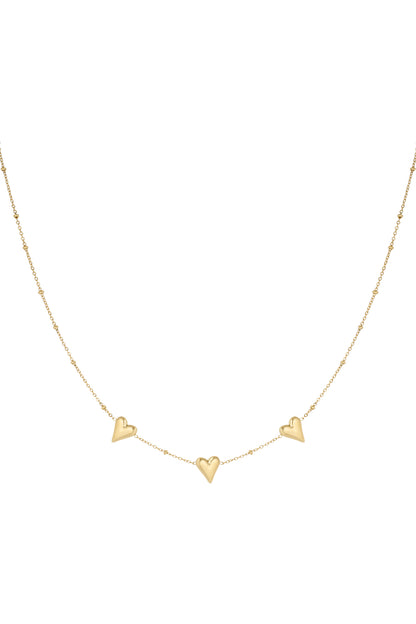 Delicate gold-tone chain necklace with three polished heart-shaped pendants evenly spaced on a fine chain with tiny bead details