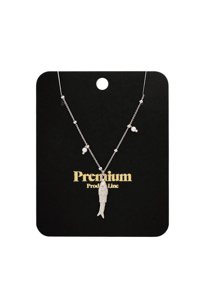 Silver fish charm necklace displayed on black premium product card